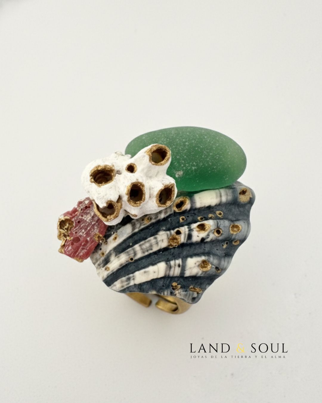 "Anillo artesanal Land & Soul con cerámica marina, cristal del mar verde y barnacles naturales sobre base de latón ajustable."