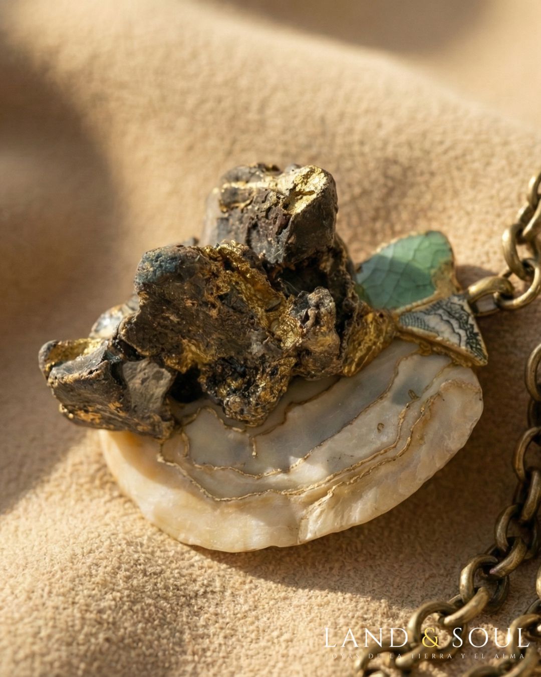 técnica kintsugi. Materiales:fragmento de concha, cerámica y una roca sintética. Cadena de eslabones color oro viejo.