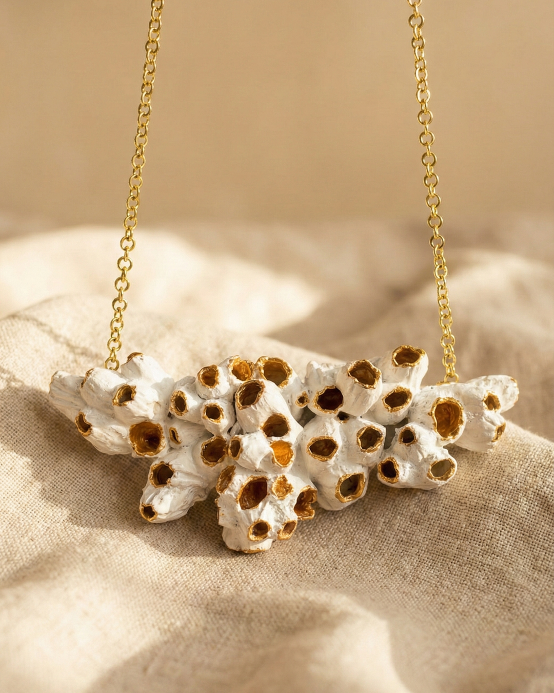 collar escultura creado con barnacles naturales y pintados en blanco y dorado