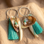 pendientes del mar creados con nácar natural, fragmento de concha y pompon